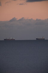 Two huge shipping boats are waiting to enter the Saint-Nazaire harbor. Le Pouliguen, France - November 17, 2025.