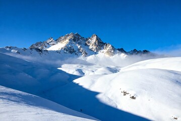 Snowy winter mountain landscape with bright blue sky, perfect nature background for travel, winter scenery, outdoor adventure and cold season visuals.