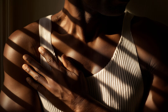 Person in dramatic light with hand on chest - Powered by Adobe