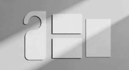 Blank white door hanger and square cards on a gray background with shadows