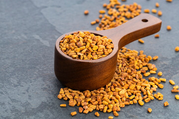 Organic raw dried fenugreek seeds in a spoon - Trigonella foenum - graecum