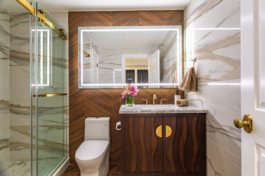 Modern Bathroom Interior with Marble Tiles and Illuminated Vanity Mirror - Powered by Adobe