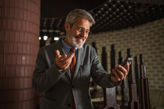Smiling senior businessman having video conference call on smart phone