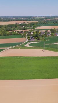 moves seneffe town green fields power lines distant windmills natural agricultural landscape forward aerial drone view belgium lush expansive 