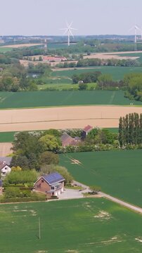 seneffe town surrounding areas green fields small houses distant windmills create charming rural scene reflecting town's to from left right pans aerial drone belgium 