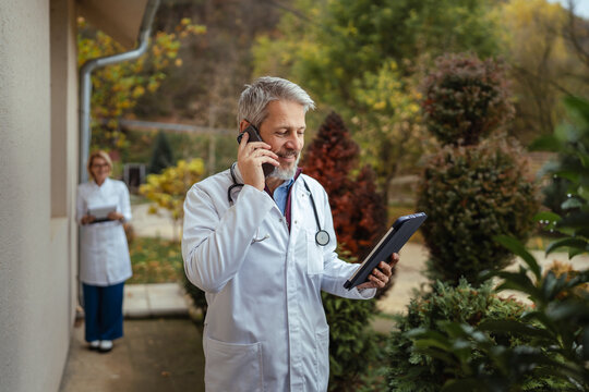 Healthcare team communicating outside with tablet and smart phone