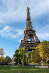 Walking in Paris in autumn, view on part trees and iconic Eiffel tower in daytime