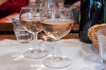 Lunchtime in France, pouring of  cold wine in glasses for lunch, wine and food pairing in Paris bistro cafe or bouillon, local cafe