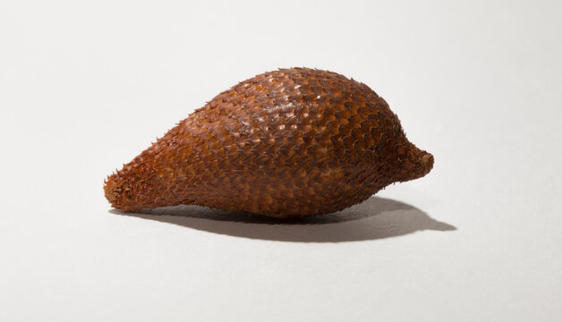 Salak (Salacca zalacca) is a species of palm tree (family Arecaceae), snake fruit or snakeskin fruit due. One fruit on a white background.