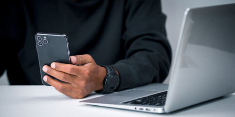 A middle-aged man holds a smartphone in his hand for various transactions such as paying for products online, shopping online, checking information, and more.