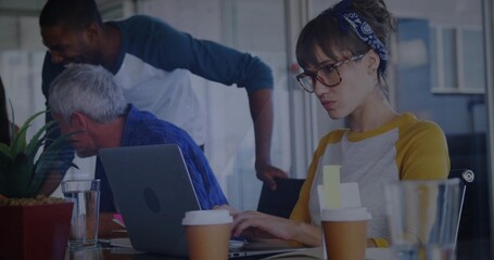 Typing woman with glasses and headband at conference table with laptop, coffee, copy space