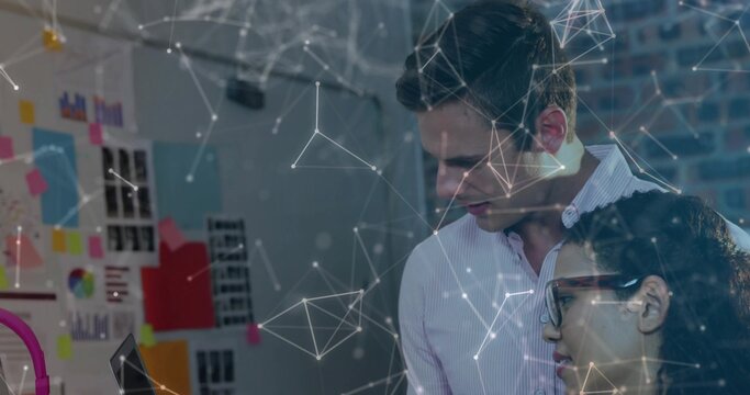 Leaning shirted man and woman in glasses studying laptop at office with charts, overlay, copy space - Powered by Adobe