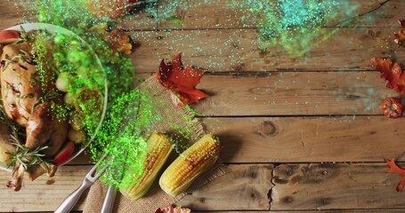 Displaying roasted turkey on platter sitting on wood table with corn, rosemary, glitter, copy space © vectorfusionart
