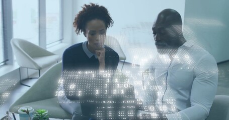 Colleagues working on laptop in lounge, woman dark sweater, man white shirt, viewing binary overlay