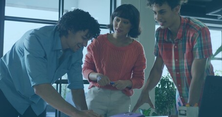 Holding pen, woman in coral sweater reviewing documents with two men at office desk, purple binder