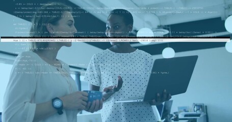 Discussing women in polka-dot blouse and watch holding laptop and blue mug in office, code overlay
