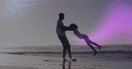 Naklejka premium Swinging father holding daughter by hands at ocean shoreline, striped shirt, purple wave overlays