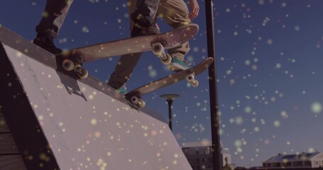 Jumping two skaters in dark, khaki pants, doing aerials at urban skate spot with skateboards, bokeh