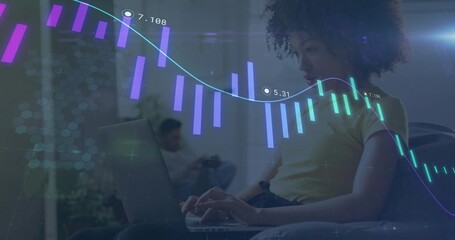 Typing woman in yellow t-shirt working on laptop in living room, with AR finance graphics