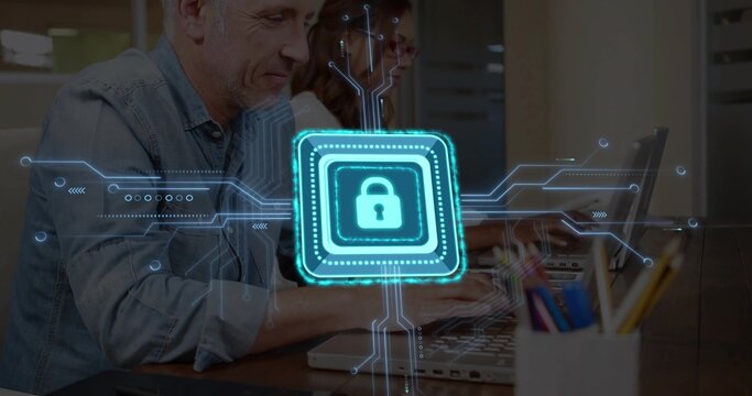 Typing man in denim and woman in glasses at office desk with laptops and padlock overlay