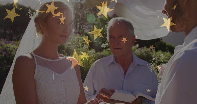 Standing wedding trio exchanging vows in garden bride wearing white lace dress veil book arch stars - Powered by Adobe