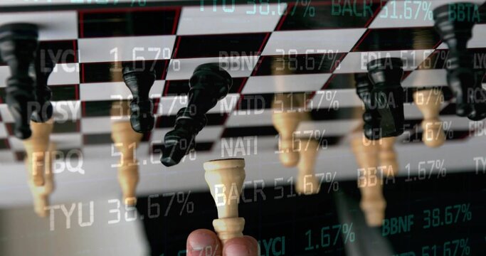 Holding hand lifting ivory king between fingers on board with reflected pieces, with market ticker