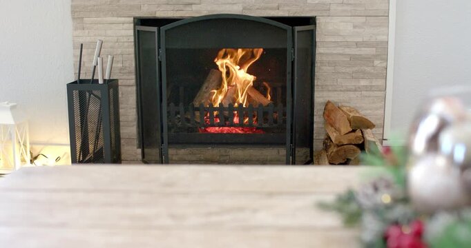 At start fire burning in metal grate on hearth, logs flickering, shrinking embers providing glow