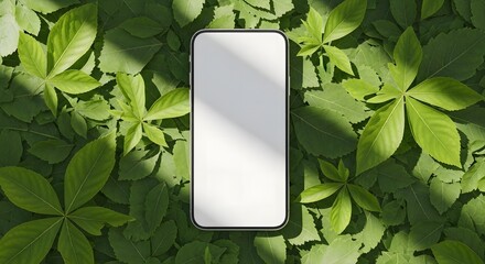 top-view smartphone mockup with blank screen, placed on a bed of fresh green leaves