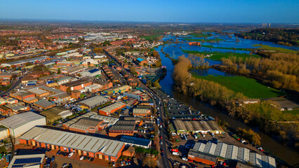 Industrial area bordering flooded river and autumn fields