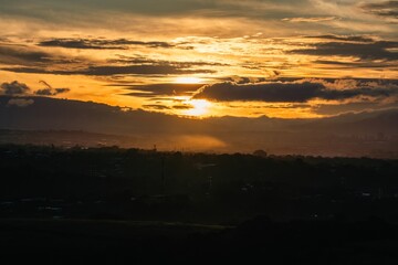 Fototapeta premium Beautiful sunrise over distant hills with golden light illuminating the sky