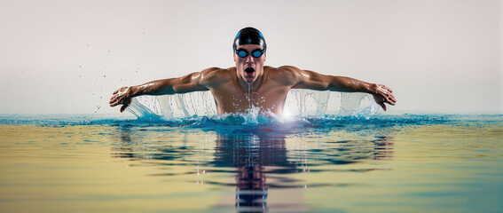 Male athlete performing butterfly stroke on reflective water surface, dynamic splash, sports strength concept, fitness, competition, training, determination