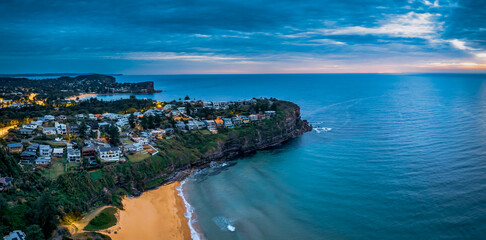 Aerial Sunrise Panorama at the Seaside with rain clouds, houses and headland views