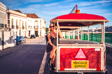 woman riding tourist train in tavira portugal at sunset