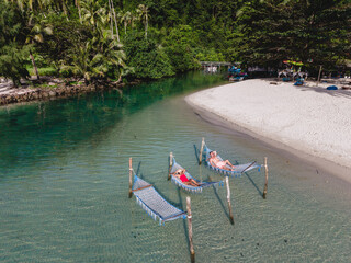 Relaxing in colorful hammocks by the crystal clear waters of Koh Kood Island in Thailand