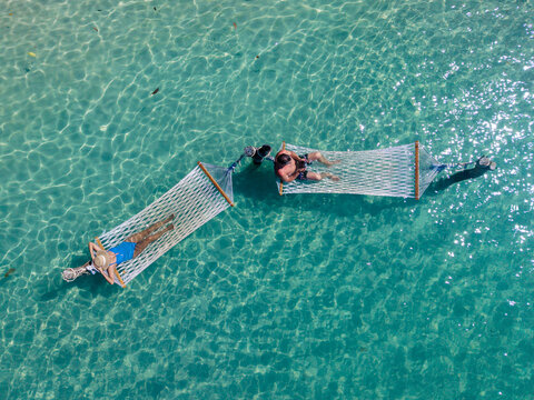 Relaxing in hammocks over the crystal-clear waters of Koh Kood Island Thailand - Powered by Adobe