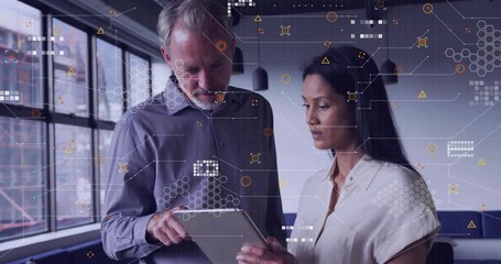 Man tapping tablet and woman holding tablet reviewing business data in office with growing graphs - Powered by Adobe