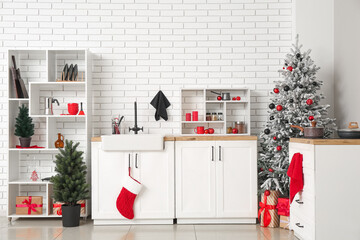 Interior of kitchen with Christmas trees, shelf units and counters