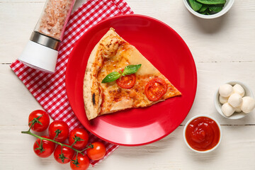 Plate with piece of tasty pizza Margarita and ingredients on white wooden background