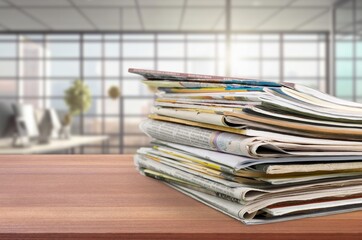 Stack of retro newspapers at different languages on desk indoors