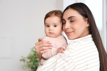 Young mother hugging her baby at home. International Hug Day