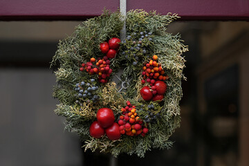 A Christmas wreath of red berries hanging on a door