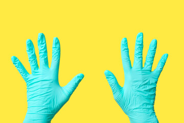 Female hands in medical gloves on yellow background