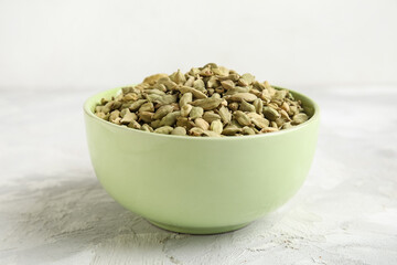Bowl with cardamom spice on grey table