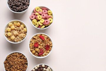 Bowls with different cereals on beige background