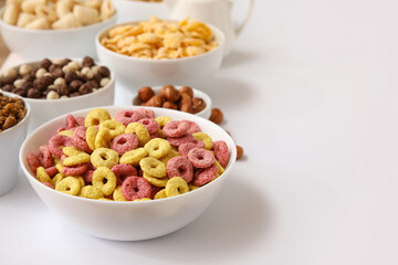 Bowl with color cereal rings on white background, closeup