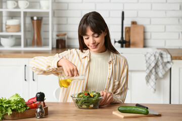 Young woman making fresh vegetable salad in  kitchen