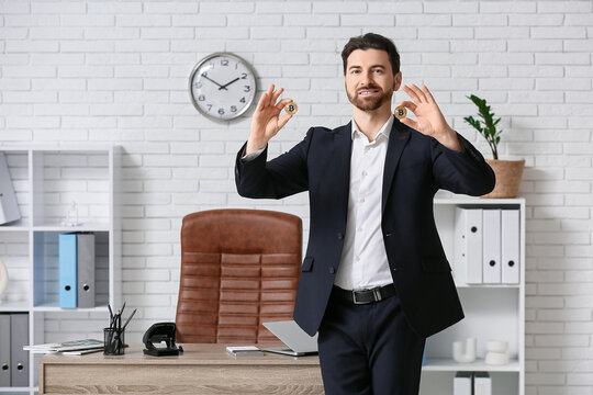Handsome businessman with bitcoins in office