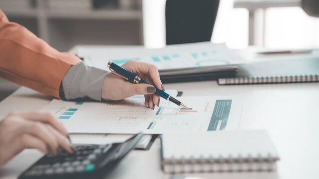 Business people discussing charts and graphs showing results of teamwork in a meeting to analyze financial reports, planning strategies, success.