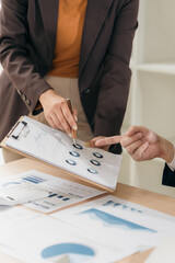 Business people discussing charts and graphs showing results of teamwork in a meeting to analyze...