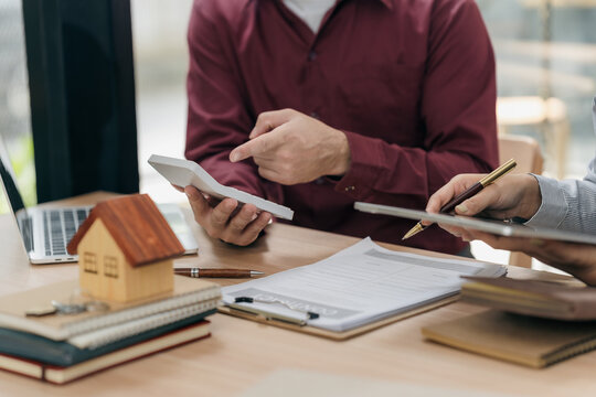 Real estate agents hand over the keys to clients after signing the contract and provide advice to clients on the decision to sign the insurance agreement form.